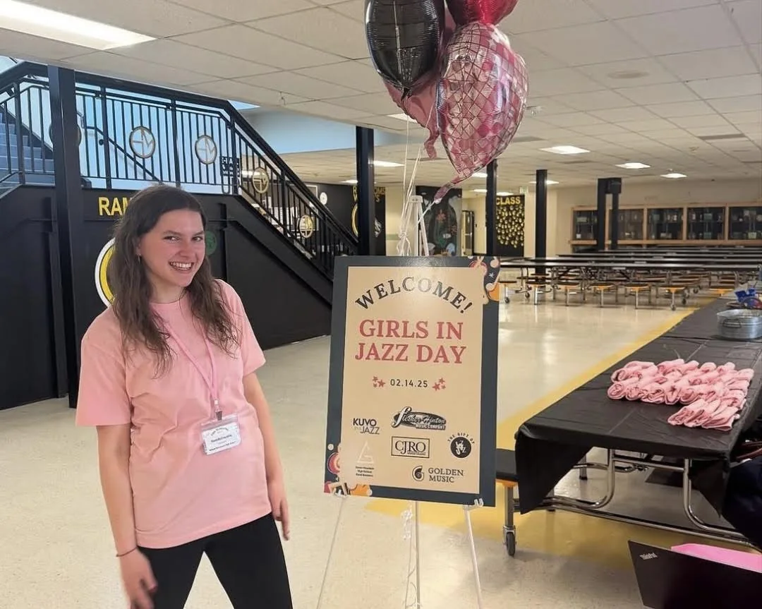 Mariella Franklin welcoming attendees beside the Girls in Jazz Day event sign