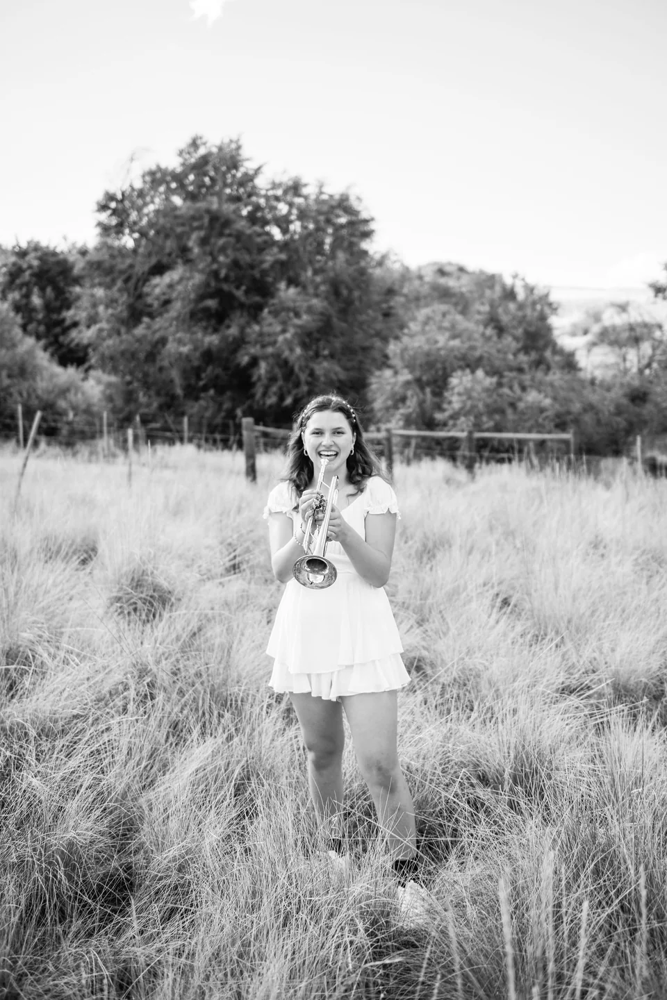 Mariella Franklin smiling while holding her trumpet in a field